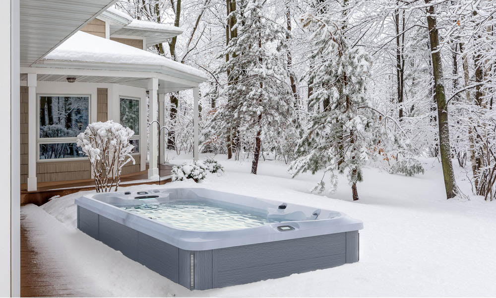 Snowy winter scene with a big house and a jacuzzi swim spa