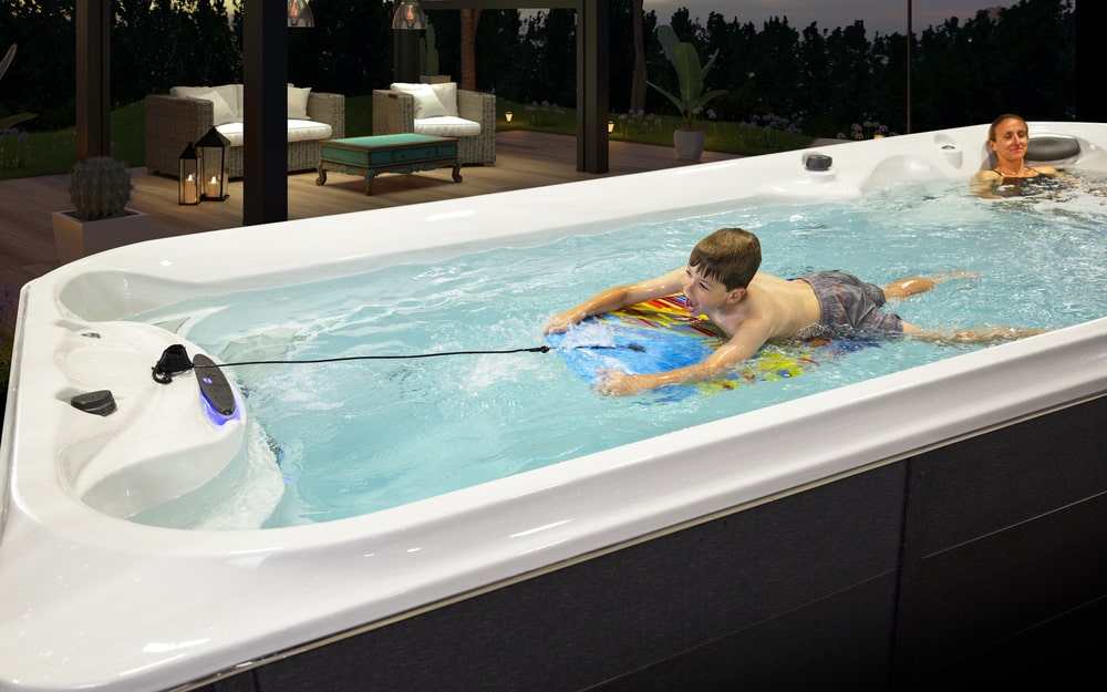 Mother relaxing and child playing in swim spa